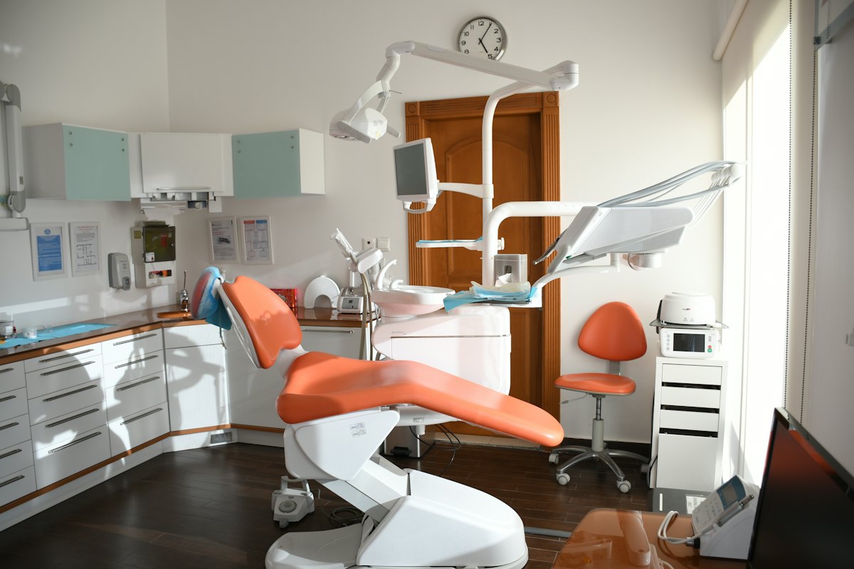 A dental chair in a sunlit clinic treatment room